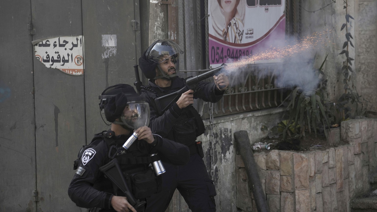 Israeli police fire riot control rounds during clashes following the demolition of the family home of Palestinian gunman Uday Tamimi, in the West Bank village of Anata, near Jerusalem, Wednesday, Jan. ...