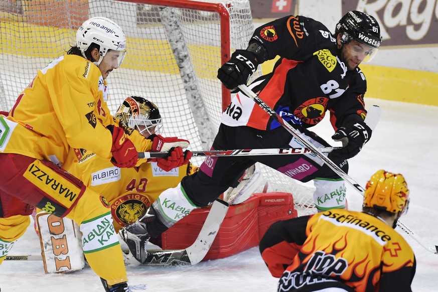 Die Berner mit Topskorer Mark Arcobello und Thomas Ruefenacht, von rechts, und die Langnauer Philippe Seudoux und Torhueter Damiano Ciacco, von links, kaempfen um den Puck beim Eishockeyspiel der Nati ...