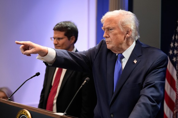 President Donald Trump, right, joined by Solicitor General John Sauer, as Trump speaks with reporters in the James Brady Press Briefing Room at the White House, Friday, Feb. 20, 2026, in Washington. ( ...