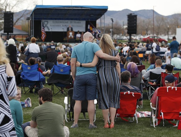 Attendees hug during a program for the victims of the massacre at Columbine High School 20 years ago Saturday, April 20, 2019, in Littleton, Colo. (AP Photo/David Zalubowski)