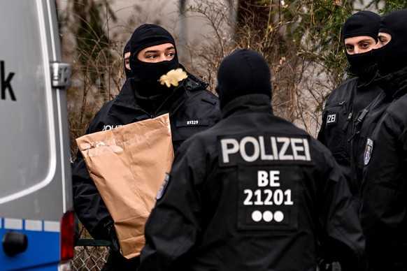 epa10353399 Police officers work during a raid in Berlin, Germany, 07 December 2022. Twenty-five people allegedly affiliated to the so-called Reichs Citizens (Reichsbuerger) movement were arrested in  ...