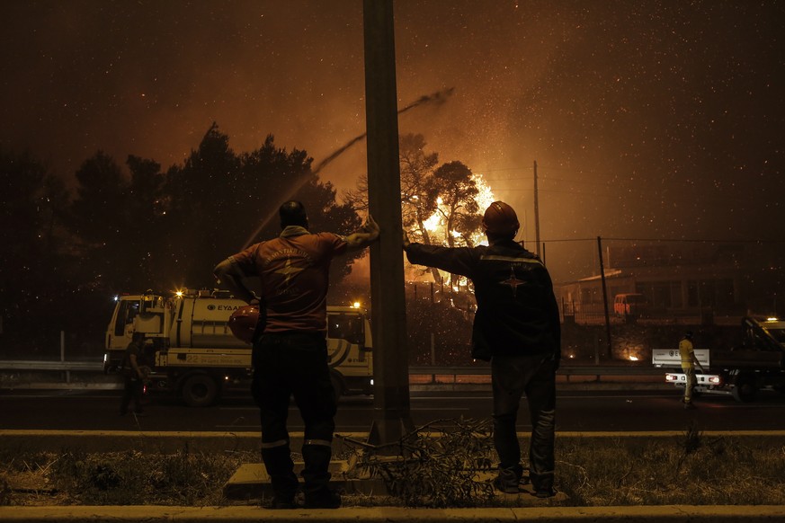 epaselect epa09399552 Volunteer firefighters look at the flames approaching a main highway in the area of Afidnes near Athens, Greece, 05 August 2021 (issued 06 August 2021). Firefighters are relying  ...