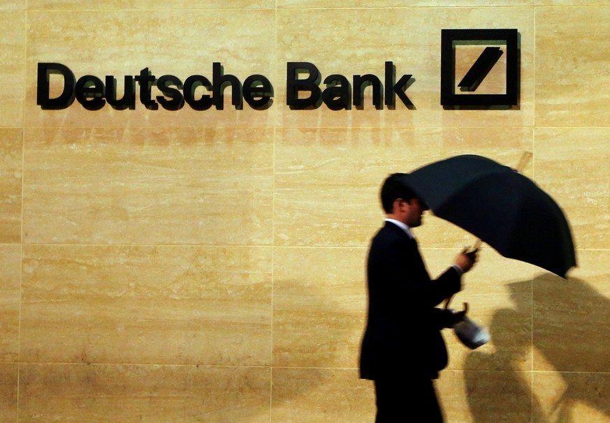 A man walks past Deutsche Bank offices in London December 5, 2013. REUTERS/Luke MacGregor/File Photo