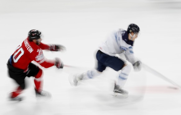 Switzerland&#039;s Denis Hollenstein, left, challenges Finland&#039;s Antti Pihlstrom, right, during the Ice Hockey World Championships group B match between Switzerland and Finland in the AccorHotels ...