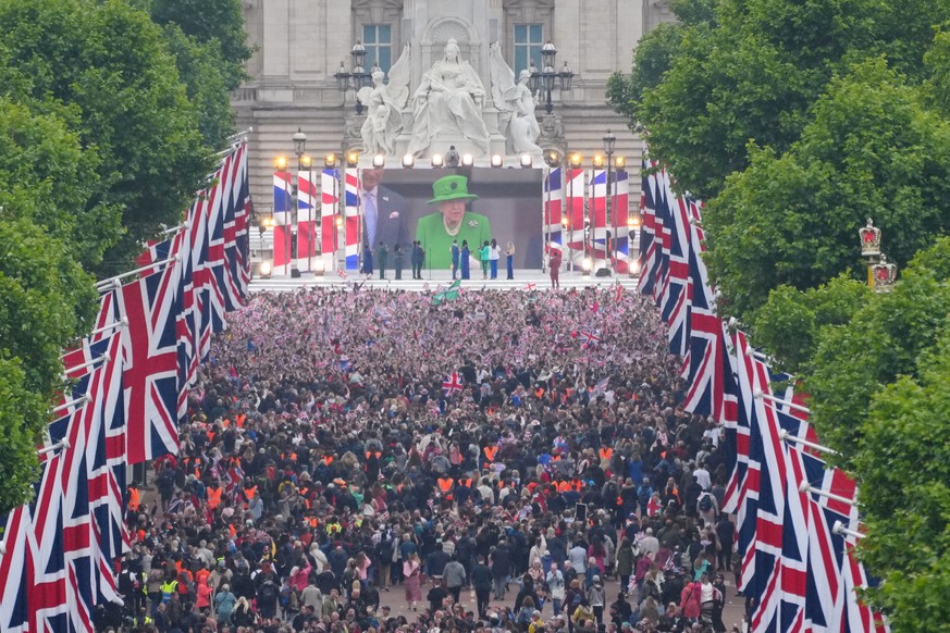 Crowds are seen on The Mall with Queen Elizabeth II shown on a screen during the singing of the National Anthem at the Platinum Jubilee in London, Sunday June 5, 2022, on the last of four days of cele ...