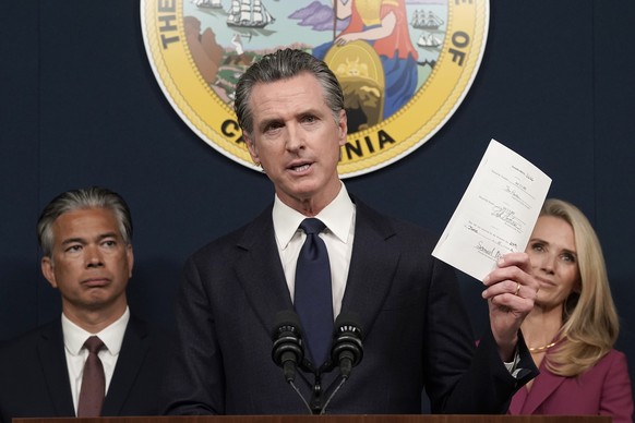California Gov. Gavin Newsom displays a bill he just signed that shields abortion providers and volunteers in California from civil judgements from out-of-state courts during a news conference in Sacr ...