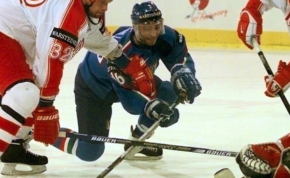 Austrian Michael Guentner, Italian Bruno Zarrillo, Austrian Patrick Pilloni and Austrian goalie Reinhard Divis (from left) try to catch the puck in front of the Austrian goal during their preliminary  ...