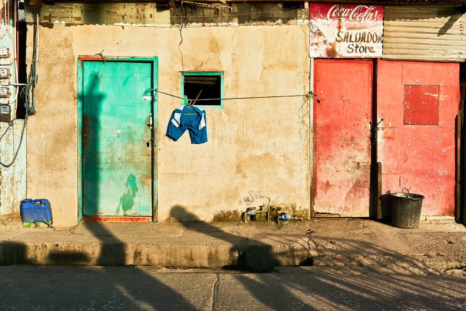 Romblon Town, Philippines - March 14, 2018: Poor building with colorful closed doors and laundry hanging on the line for drying at late afternoon