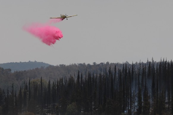epa12066824 A firefighting aircraft dousing a fire with retardant in the Latrun area, in central Israel, between Jerusalem and Tel Aviv, 01 May 2025. Magen David Adom (MDA), Israel&#039;s national eme ...