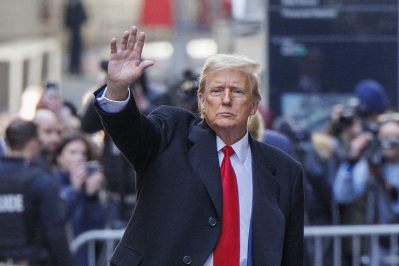 epa11243237 Former US president Donald Trump waves to spectators as he departs 40 Wall Street after a press conference about his case in criminal court in New York, New York, USA, 25 March 2024. A jud ...
