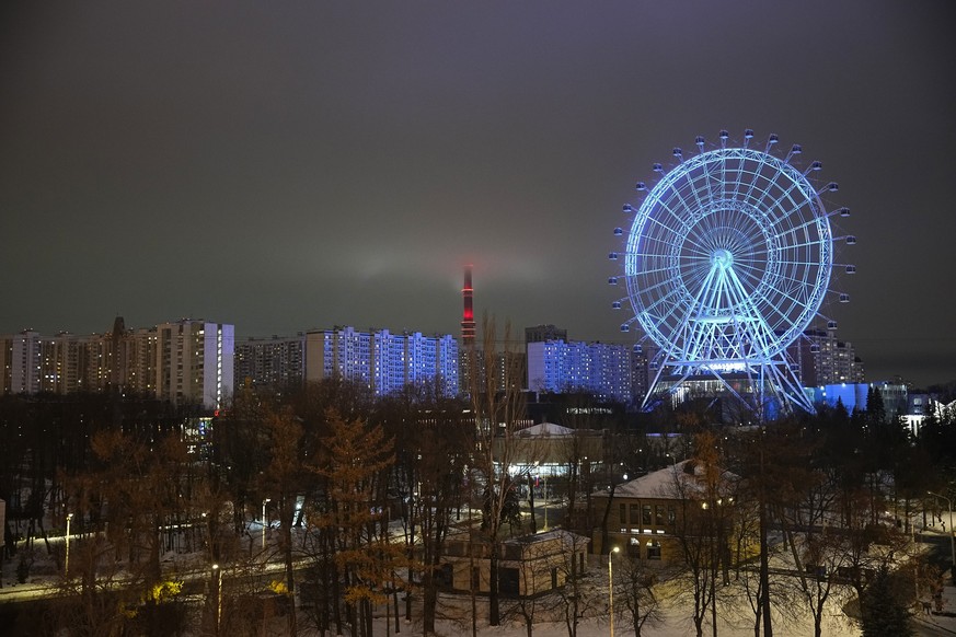 The newly opened ferris wheel at VDNKh, The Exhibition of Achievements of National Economy is seen against the Ostankinskaya TW Tower half in the clouds in Moscow, Russia, Friday, Nov. 25, 2022. (AP P ...