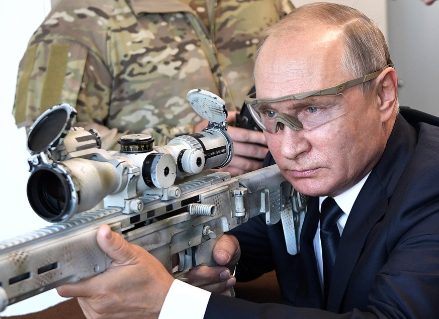 Russian President Vladimir Putin aims a sniper rifle during a visit to the Patriot military exhibition center outside Moscow, Russia, Wednesday, Sept. 19, 2018. Putin chaired a meeting that focused on ...