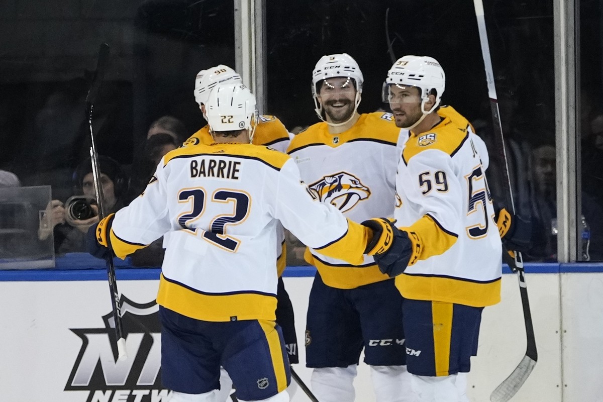 Nashville Predators' Filip Forsberg (9) celebrates with teammates Tyson Barrie (22) and Roman Josi (59) after scoring a goal during the second period of an NHL hockey game against the New York Ra ...