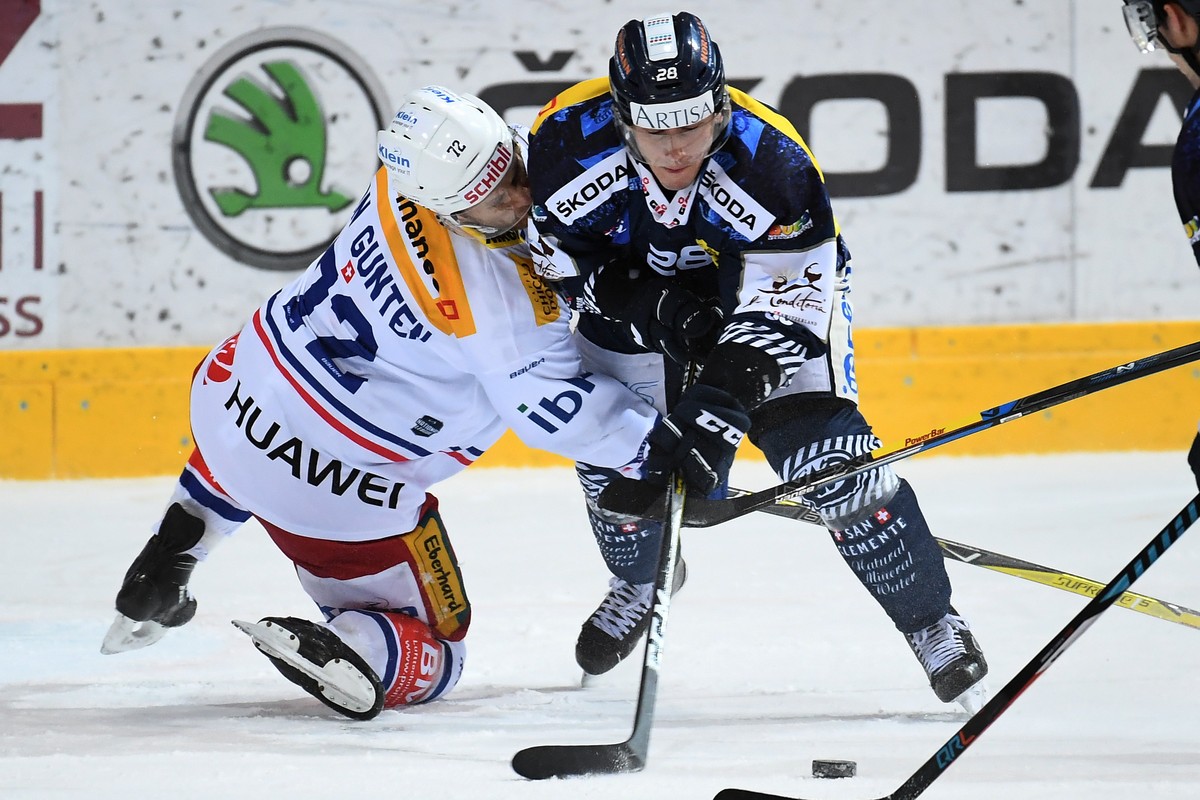 Kloten's player Patrick von Gunten, left, fights for the puck with Ambri's player Eliot Berthon, right, during the preliminary round game of National League Swiss Championship 2017/18 betwee ...