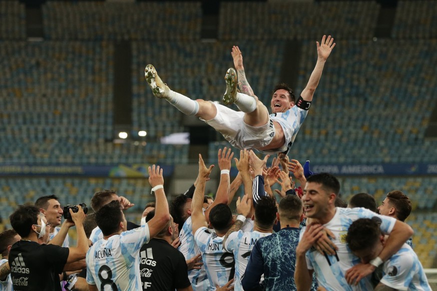 epa09336522 Players from Argentina toss in the air their teammate Lionel Messi as they celebrate their victory against Brazil in the Copa America final soccer match at Maracana Stadium in Rio de Janei ...