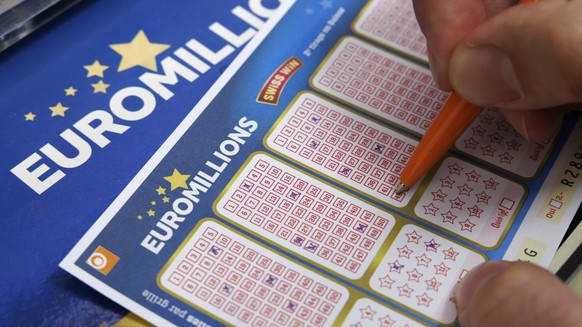Un homme coche des numeros sur des bulletins de l' Euro Millions de la Loterie Romande dans le kiosque de Josephine, ce lundi 16 octobre 2023 a Cheseaux-sur-Lausanne pres de Lausanne. (KEYSTONE/S ...