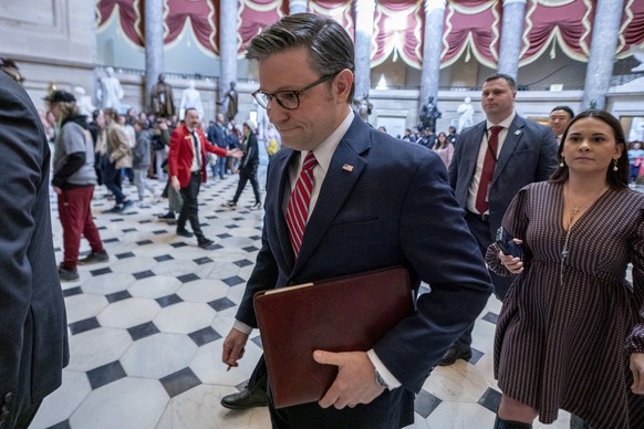 epa11236519 US Speaker of the House Mike Johnson (C) walks through Statuary Hall to the House floor to vote on the USD 1.2 trillion funding package in the US Capitol in Washington, DC, USA, 22 March 2 ...