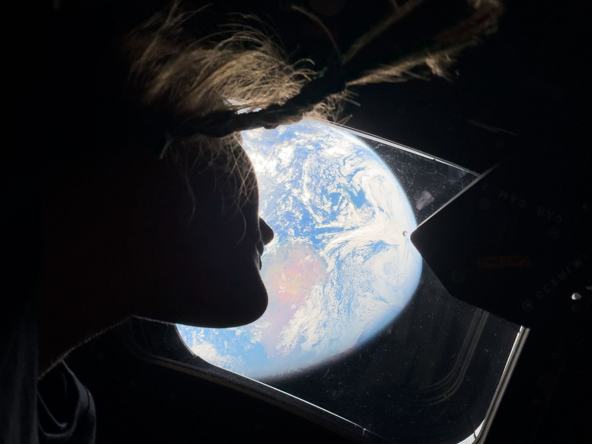 KEYPIX - This image provided by NASA, astronaut and Artemis II mission specialist Christina Koch peers out of one of the Orion spacecraft's main cabin windows, looking back at Earth, as the crew  ...