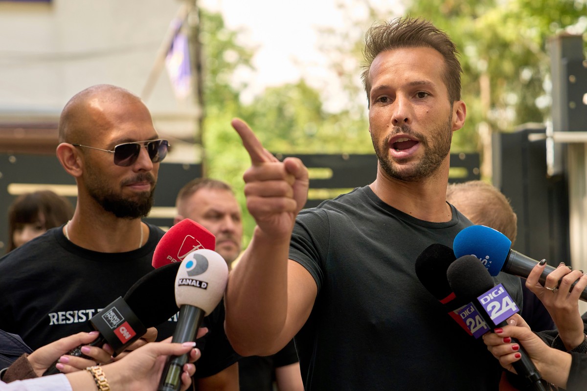 FILE - Andrew Tate, left, watches his brother Tristan speak, outside a police station in Voluntari, Romania, May 21, 2025. (AP Photo/Vadim Ghirda, File)
Tate Brothers