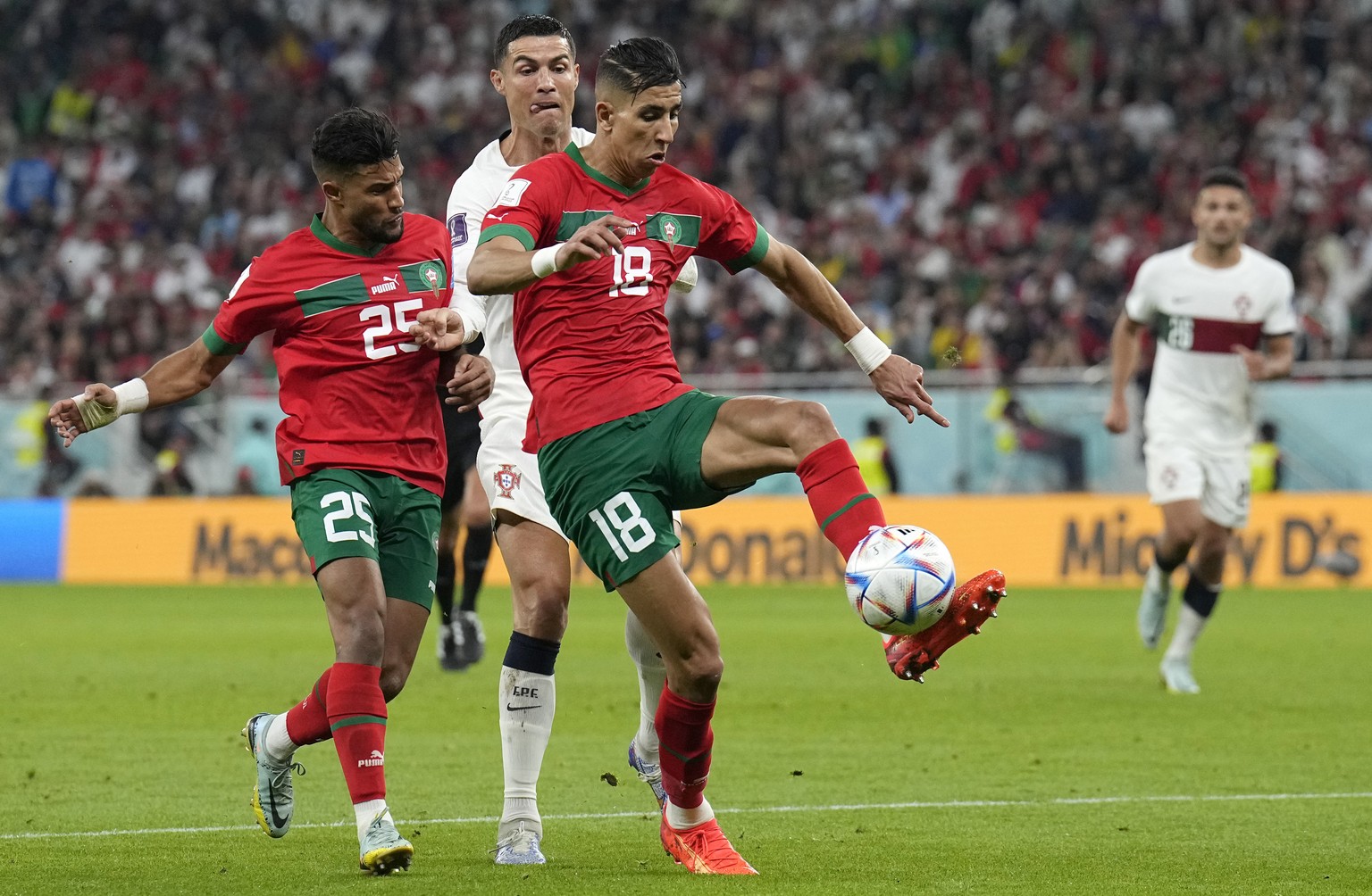 Portugal&#039;s Cristiano Ronaldo challenges for the ball with Morocco&#039;s Jawad El Yamiq, right, during the World Cup quarterfinal soccer match between Morocco and Portugal, at Al Thumama Stadium  ...