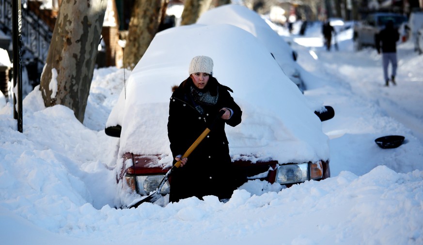 Die Hauptbeschäftigung des New Yorkers am Sonntag: Schneeschippen — eine junge Frau in Brooklyn befreit ihren Wagen von der Schneemenge.