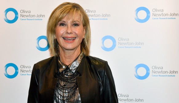 epa10111817 (FILE) - British-Australian actor, singer and breast-cancer activist Olivia Newton-John smiles while posing for the media as she attends a Cancer Research Institute event at the Parliament ...