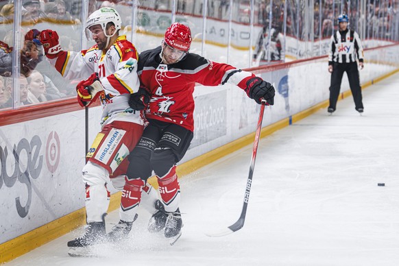 L&#039;attaquant biennois Yanik Burren, gauche, lutte pour le puck avec le defenseur lausannois Makai Holdener, droite, lors du match du championnat suisse de hockey sur glace de National League entre ...