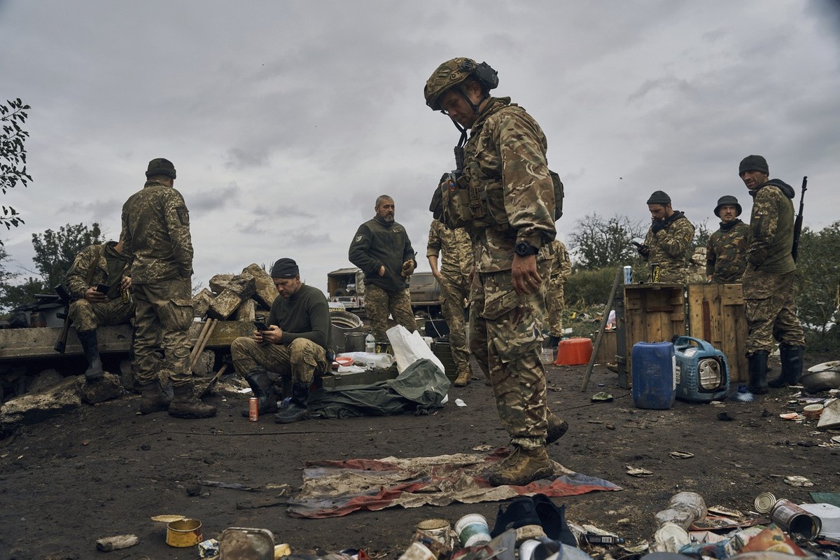 A Ukrainian soldier stands on the Russian flag in Izium, Kharkiv region, Ukraine, Tuesday, Sept. 13, 2022. Ukrainian troops piled pressure on retreating Russian forces Tuesday, pressing deeper into oc ...