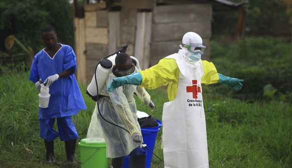 FILE - In this Sunday, Sept 9, 2018 file photo, a health worker sprays disinfectant on his colleague after working at an Ebola treatment centre in Beni, Eastern Congo. Congo's health ministry says a b ...