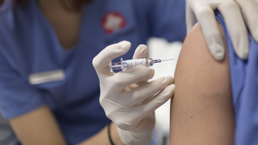 ARCHIVBILD ZUR EMPFEHLUNG DES BAG SICH GEGEN DIE GRIPPE ZU IMPFEN, AM DIENSTAG, 23. OKTOBER 2018 - A medical assistant gives a flu vaccination at the Arzthaus in Zurich, Switzerland, on January 30, 20 ...