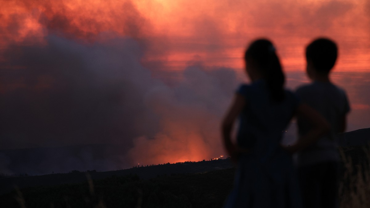 epa12271461 Children watch the fire in Arouca, Portugal, 29 July 2025. The fire that has been raging for more than 24 hours in Arouca, in the district of Aveiro, has three active fronts and has alread ...