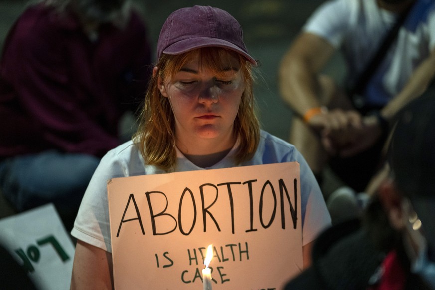An abortion-rights protester participates in a candlelight vigil for reproductive freedom and abortion rights outside the Supreme Court in Washington, Sunday, June 26, 2022. (AP Photo/Gemunu Amarasing ...