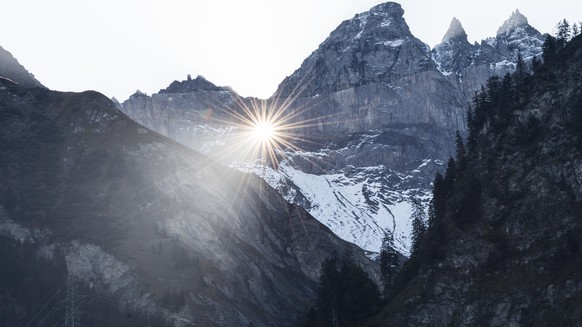 Die Sonne scheint durchs Martinsloch in den Tschingelhoernern auf das Dorf und die Kirche, aufgenommen am Mittwoch, 30. September 2015, in Elm. Die Sonne scheint jeweils im Fruehling und Herbst nur fu ...