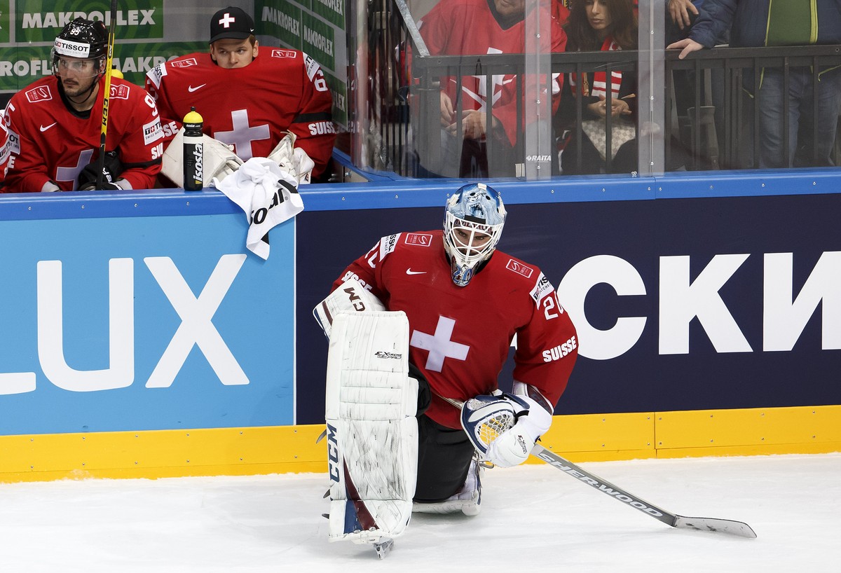 Switzerland's goaltender Reto Berra, right, looks on disappointed in front of his teammates Julian Walker, left, and goaltender Leonardo Genoni, center, during the IIHF 2015 World Championship pr ...