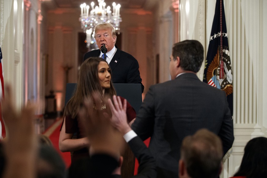 President Donald Trump watches as a White House aide takes away a microphone from CNN journalist Jim Acosta during a news conference in the East Room of the White House, Wednesday, Nov. 7, 2018, in Wa ...