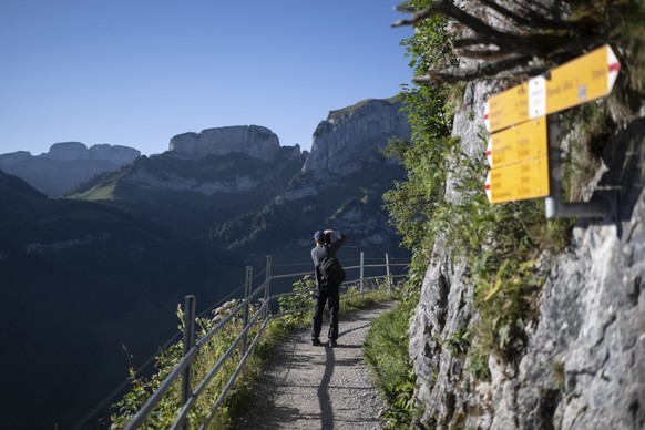 Wanderer und Wanderwegweiser zwischen Ebenalp und Aescher, aufgenommen am Dienstag, 9. August 2022, in Wasserauen. (KEYSTONE/Gian Ehrenzeller)