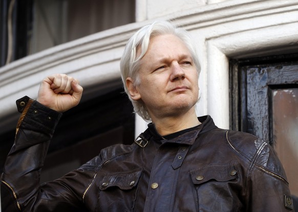 FILE - In this Friday May 19, 2017 file photo, Julian Assange greets supporters outside the Ecuadorian embassy in London. Britain