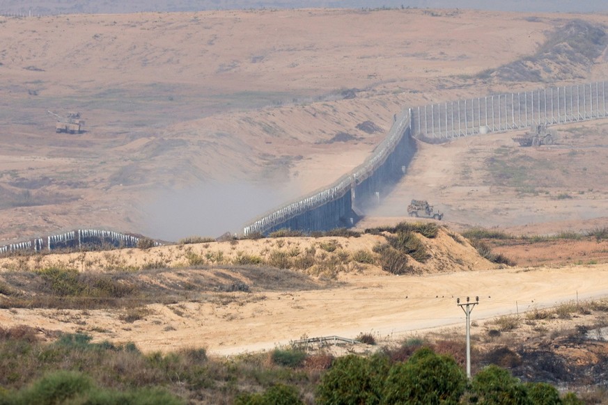 epa10965763 An Israeli tank maneuvers inside the northern part of the Gaza Strip as an Israeli military vehicle crosses the border with Israel, as seen from Sderot, southern Israel, 09 November 2023.  ...