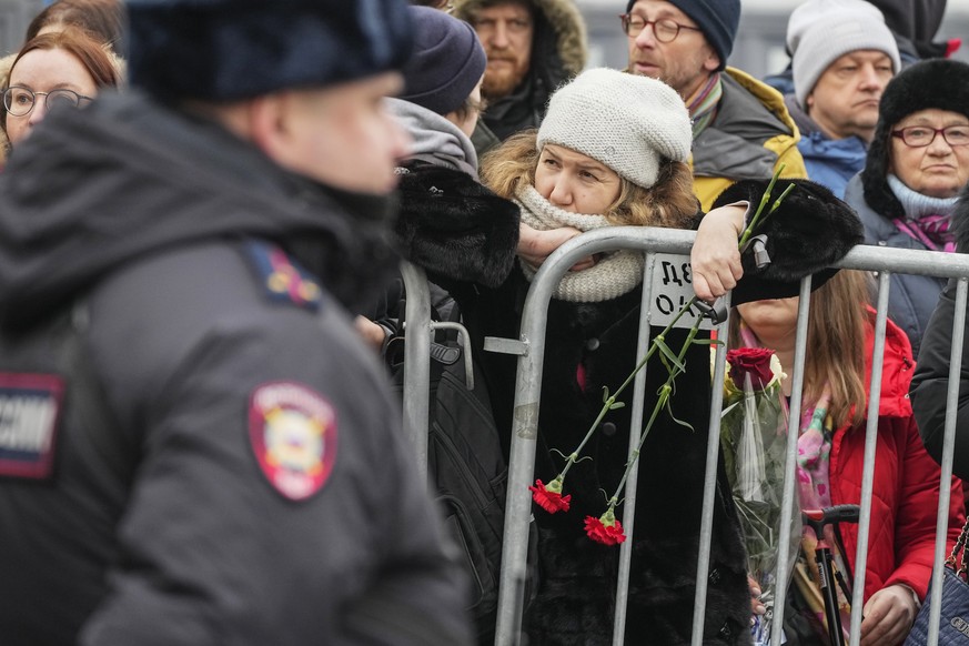 A police officer guards as people gather at the Church of the Icon of the Mother of God, in Moscow, Russia, Friday, March 1, 2024. Relatives and supporters of Alexei Navalny are bi...