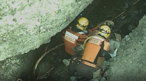 In this photo released by the 1st Regional Japan Coast Guard Headquarters, rescuers attend a person found on a rocky area near the tip of Shiretoko Peninsula in northern Japan of Hokkaido Sunday, Apri ...