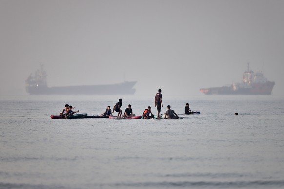KEYPIX - People gather on paddleboards in shallow water as cargo and service vessels are anchored in the Strait of Hormuz off Bandar Abbas, Iran, Monday, June 1, 2026. (Amirhosein Khorgooi/ISNA via AP ...