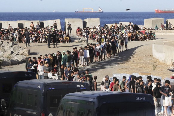 epa13195371 Red Cross members distribute food to migrants at El Trampolin beach in Ceuta, 27 August 2026. Protests erupted in the Spanish enclave of Ceuta over the past two days, with residents demand ...