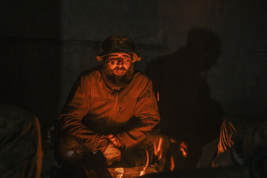 In this photo provided by Azov Special Forces Regiment of the Ukrainian National Guard Press Office, A Ukrainian soldier inside the ruined Azovstal steel plant takes a rest in his shelter in Mariupol, ...