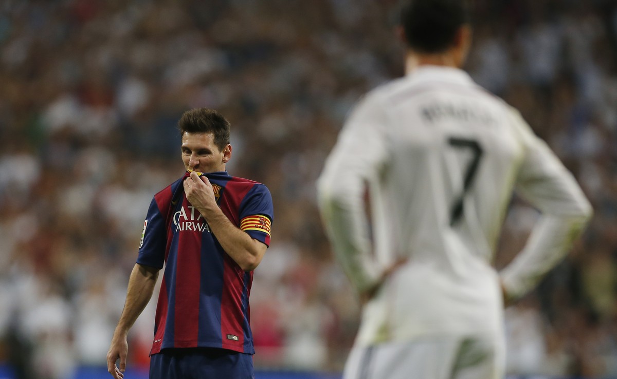 Barcelona's Lionel Messi, left, gestures next to Real Madrid's Cristiano Ronaldo, right, during a Spanish La Liga soccer match between Real Madrid and FC Barcelona at the Santiago Bernabeu s ...