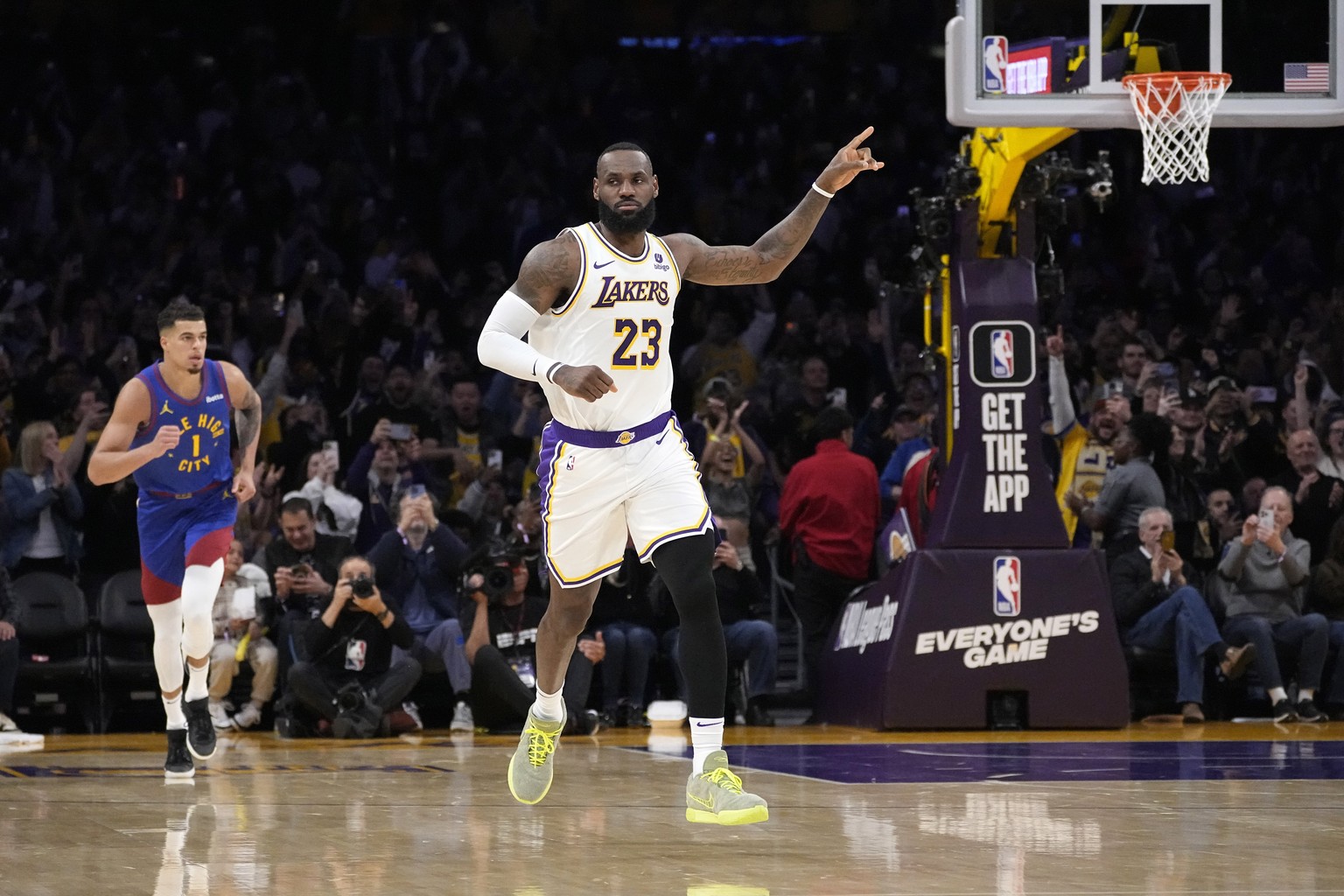 Los Angeles Lakers forward LeBron James, right, gestures after scoring to become the first NBA player to reach 40,000 points in a career as Denver Nuggets forward Michael Porter Jr. runs behind during ...