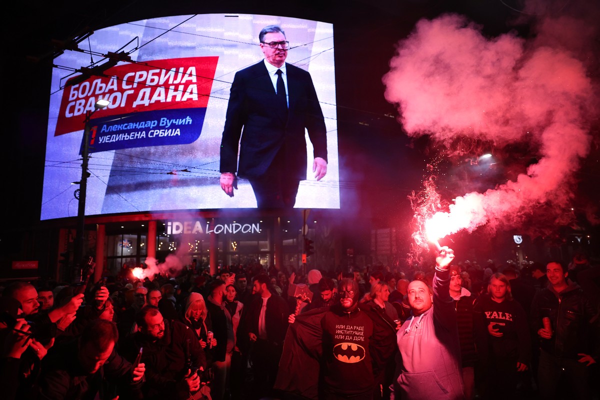 People celebrate after Aleksandar Vucic, leader of the right-wing Serbian Progressive Party (SNS) , seen on the top display, conceded defeat in the parliamentary election in Belgrade, Serbia, Sunday,  ...