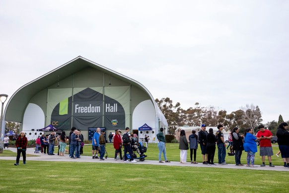 People line up for dinner outside Freedom Hall, where an evacuation center is set up, at Mile Square Regional Park in Fountain Valley, Calif., Saturday, May 23, 2026, after a chemical tank was damaged ...
