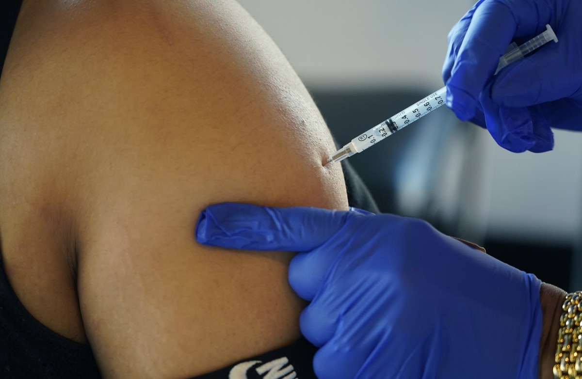 FILE - A Jackson, Miss., resident receives a Pfizer booster shot from a nurse at a vaccination site Feb. 8, 2022. Pfizer is asking the Food and Drug Administration to expand use of its updated COVID-1 ...
