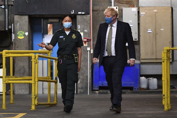 Britain&#039;s Prime Minister Boris Johnson, wearing a face mask, talks with paramedic Cindy Fu during a visit to the headquarters of the London Ambulance Service NHS Trust in London, Monday July 13,  ...