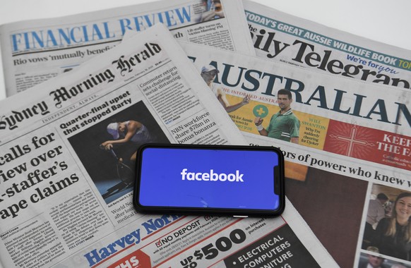 epa09020239 An illustration image shows a phone screen with the Facebook logo and Australian Newspapers at Parliament House in Canberra, Australia, 18 February 2021. Social media giant Facebook has mo ...